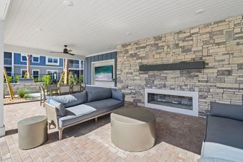 Covered outdoor lounge with fireplace and stone feature wall